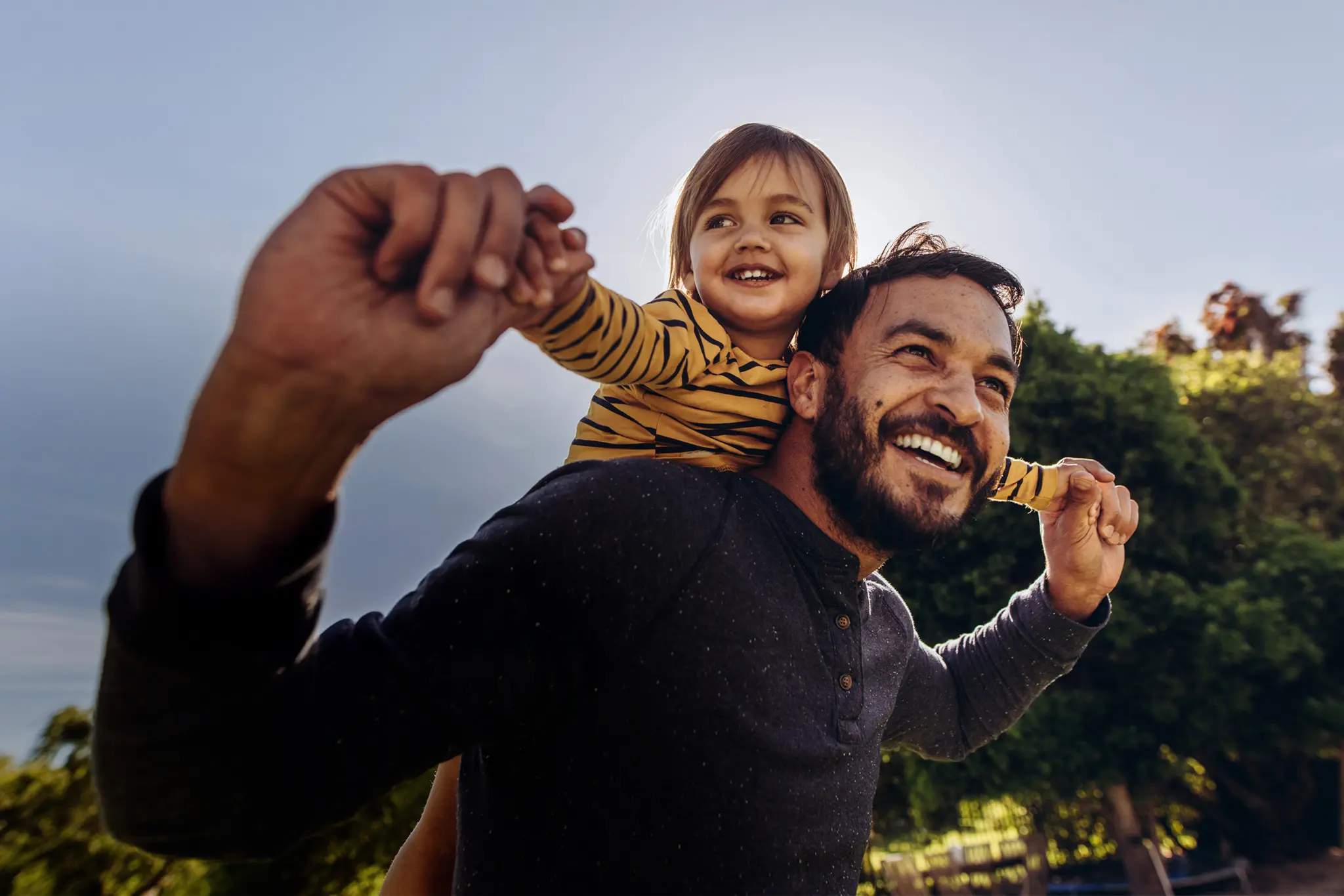 A child sitting on their dad's shoulders.