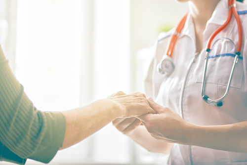 image of a medical provider holding the hand of a patient