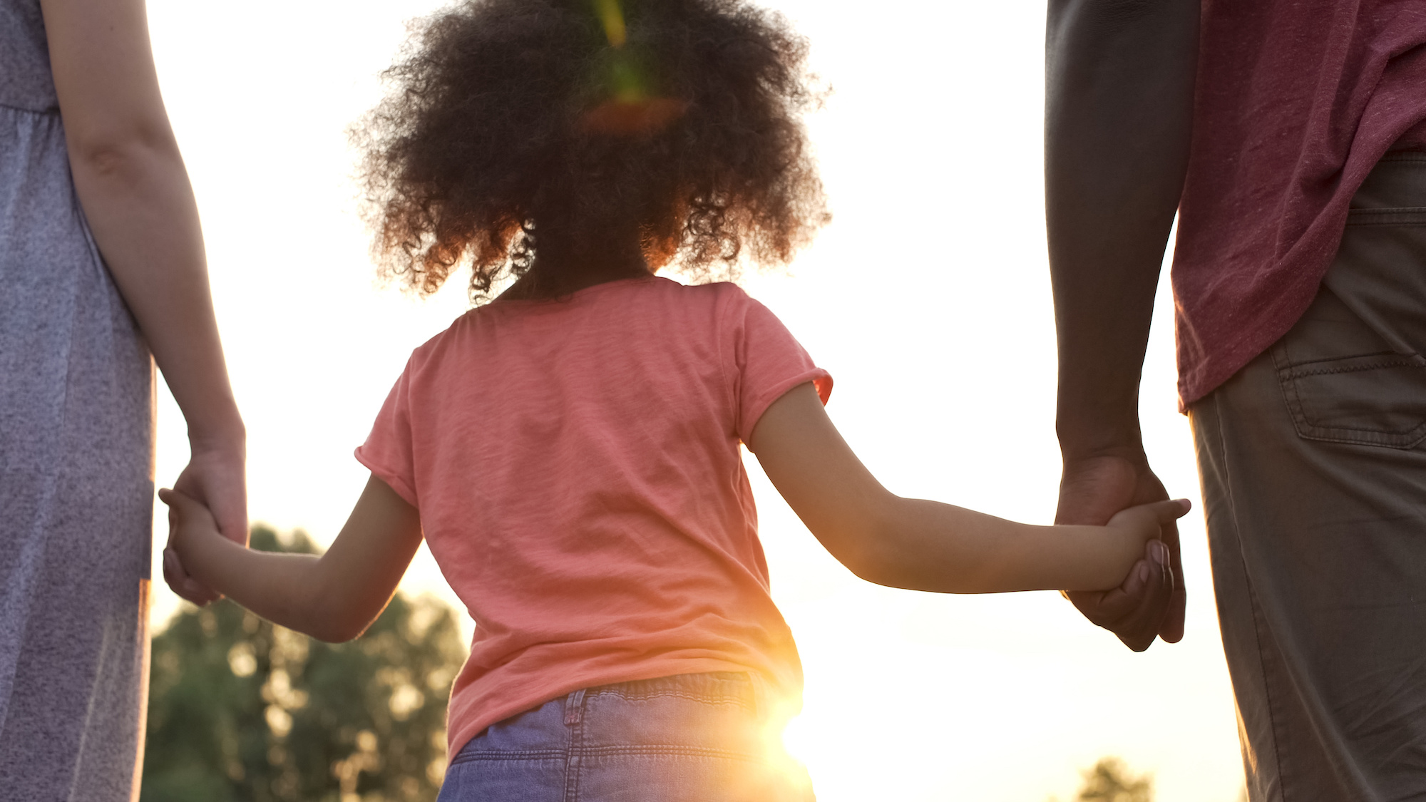 Little girl holds fathers and mothers hands