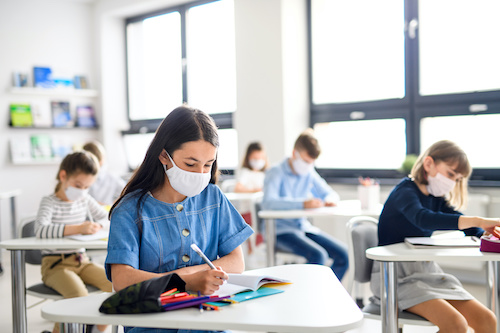 children in masks in a classroom setting