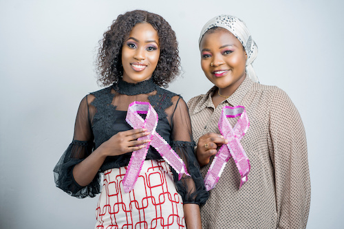 two Black women holding pink breast cancer awareness ribbons