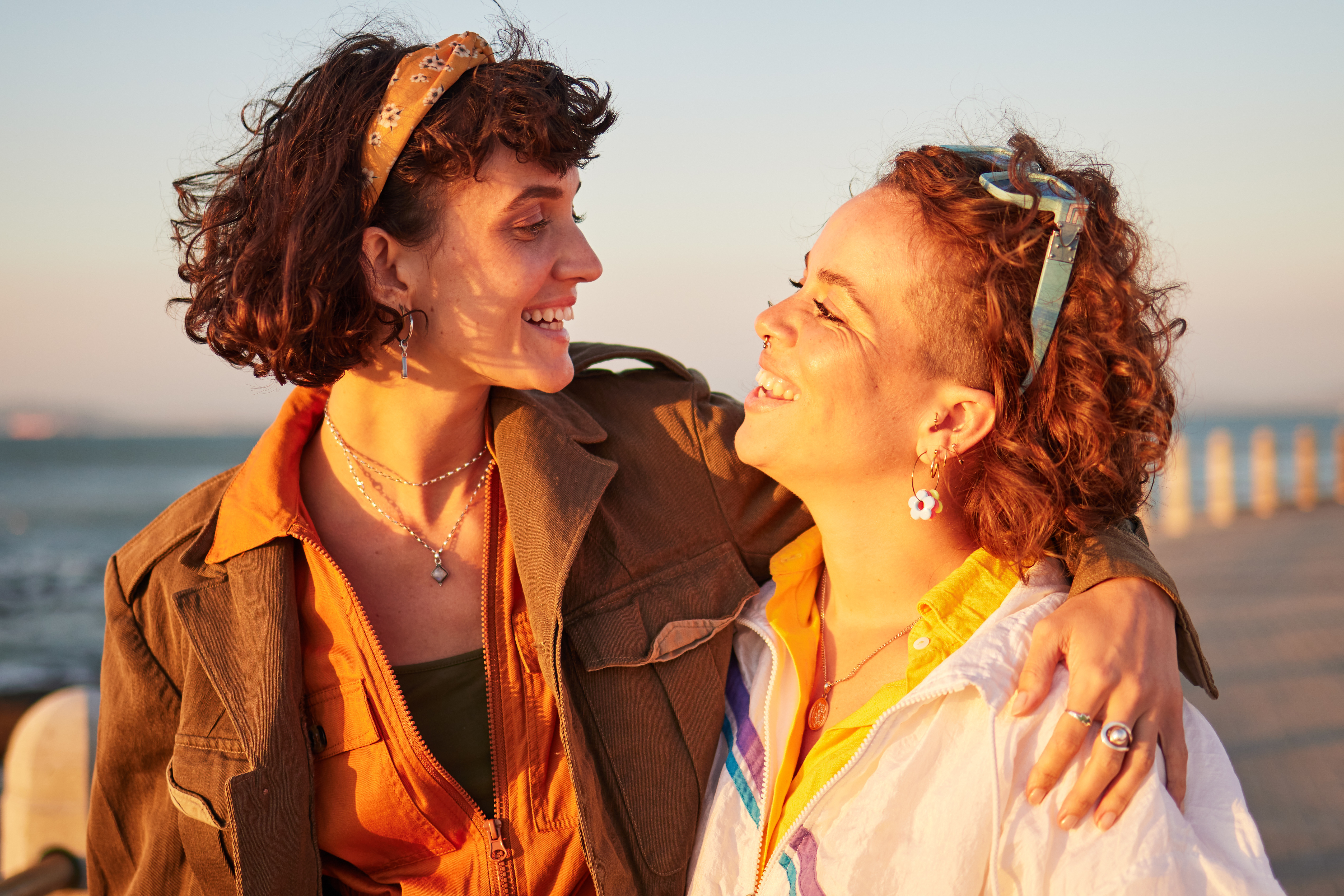 Two women smiling at each other during sunset
