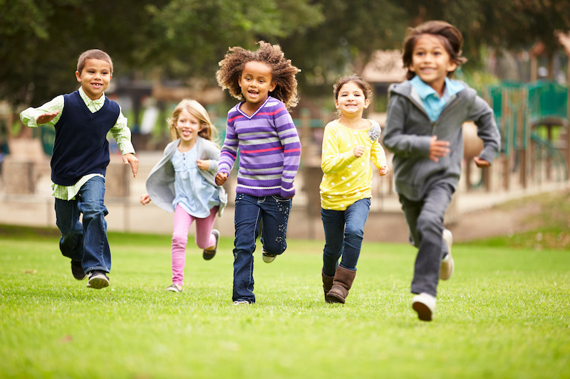 group of diverse children running in a field