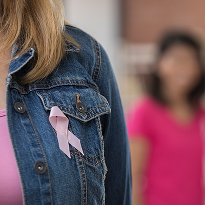 woman in jean jacket with pink ribbon