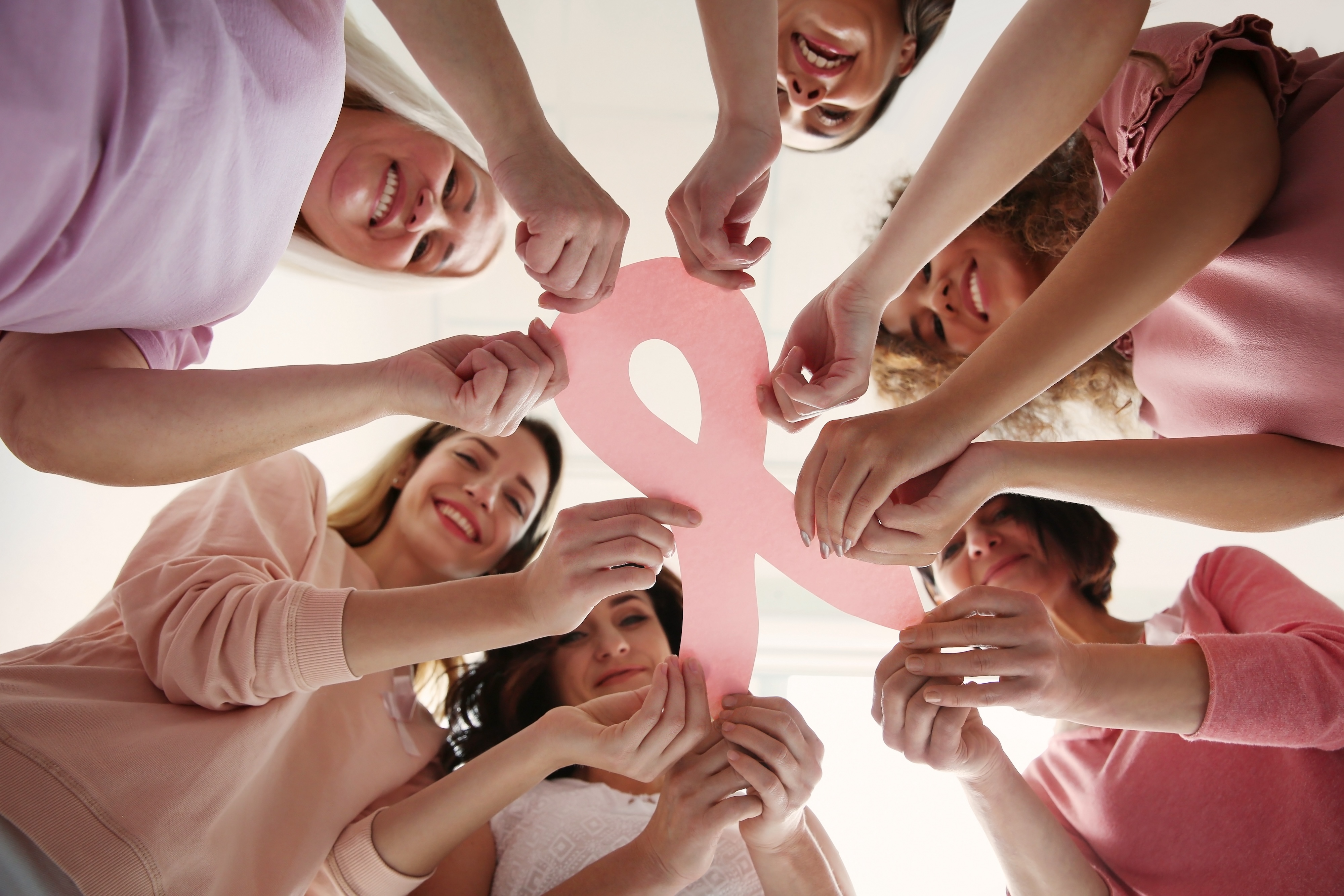 Black woman holds pink cancer ribbon in her palms