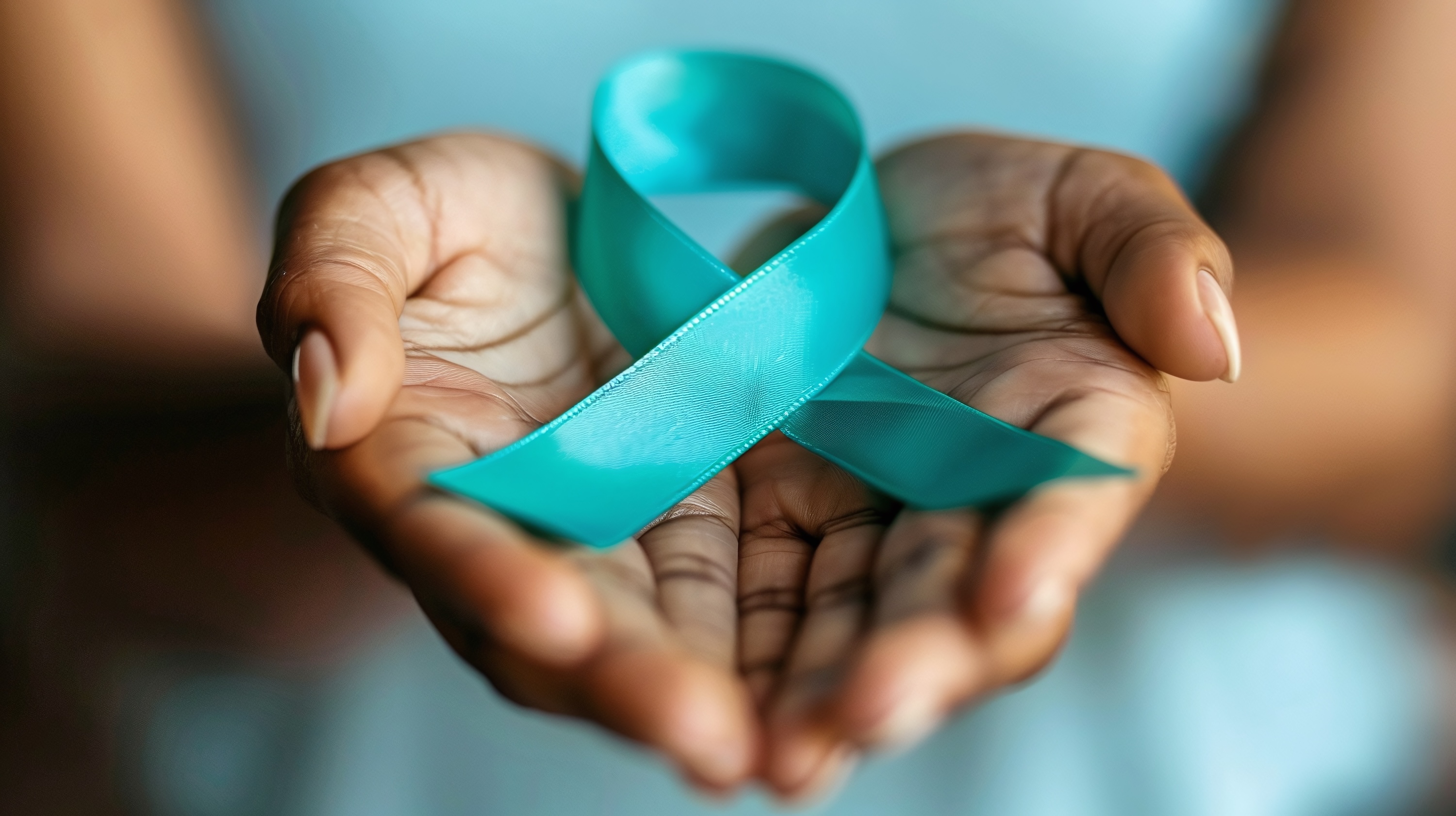 Woman holding teal ribbon for cervical cancer awareness