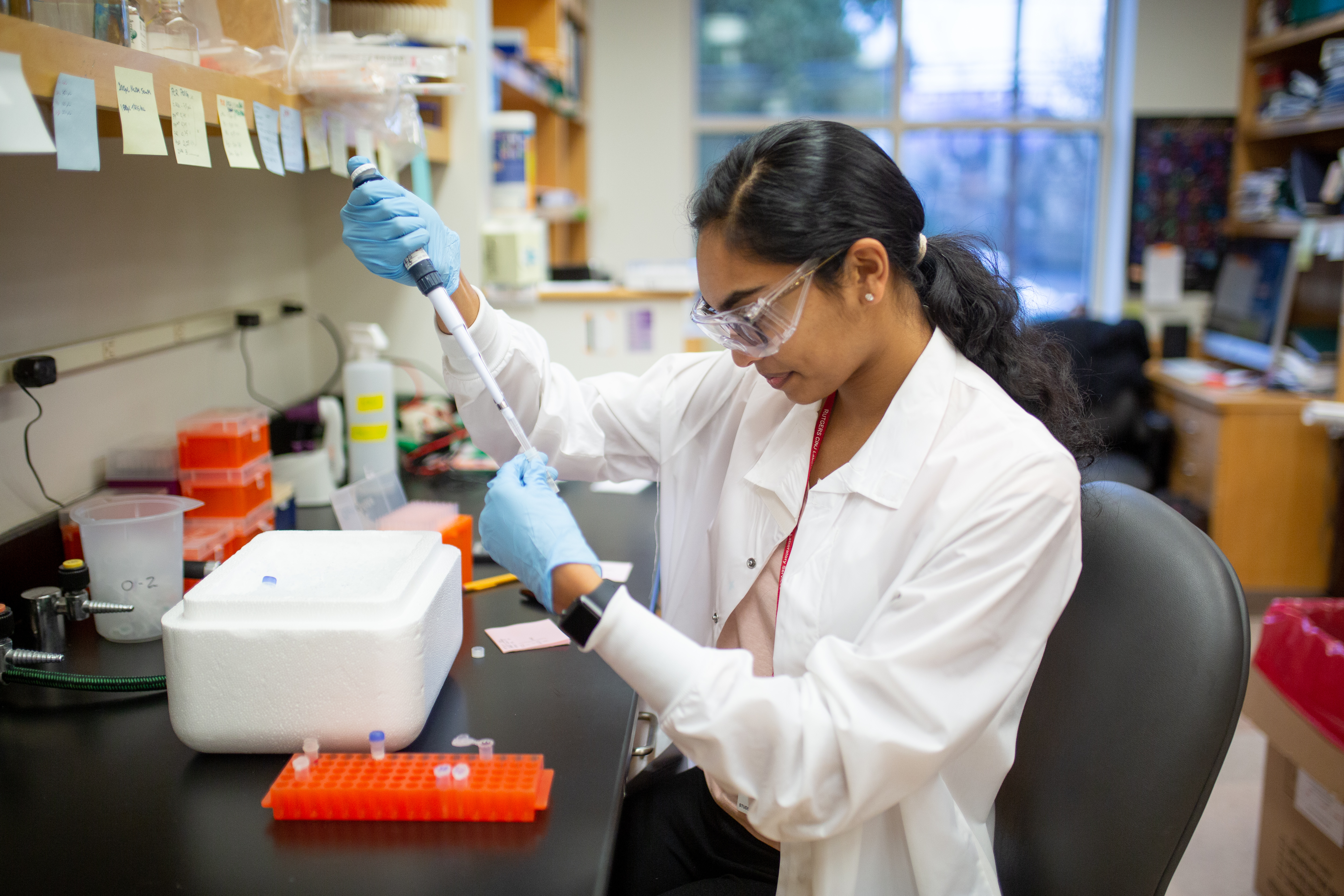 Rutgers Cancer Institute researcher using pipette to fill test tube