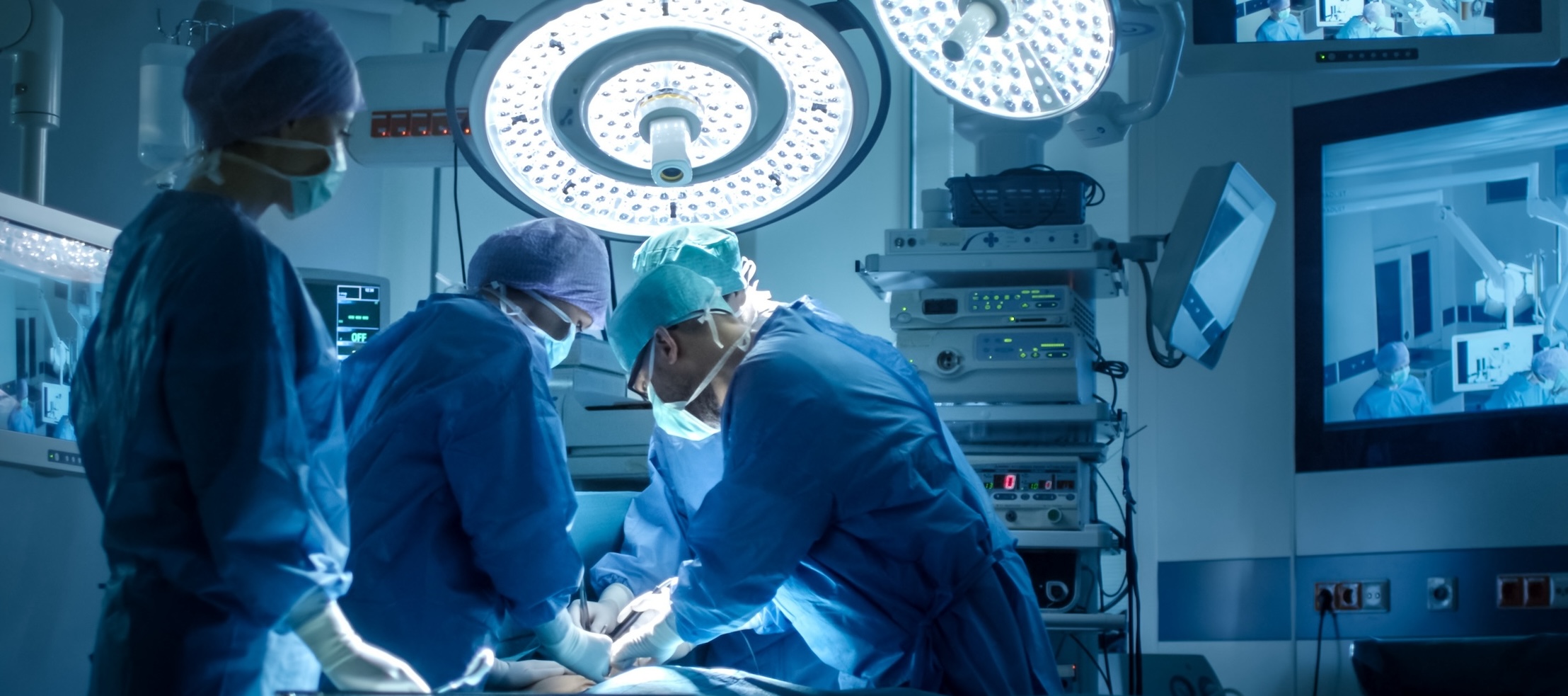 Surgical team standing over patient in Operating Room