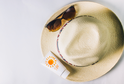 sunhats and sunscreen on a white background