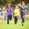 group of kids running in a park