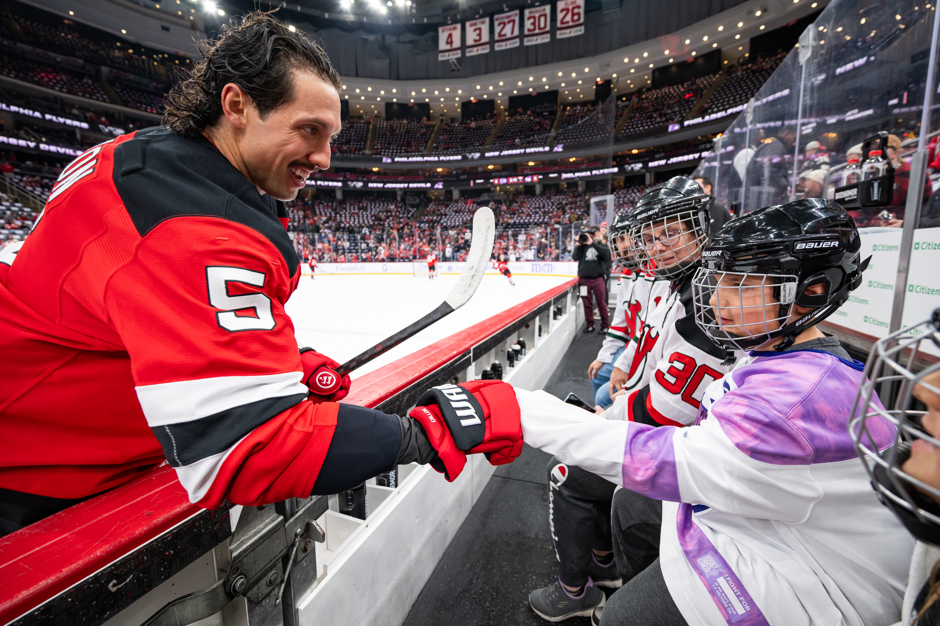 NJ Devils Player giving fist bump to child fan