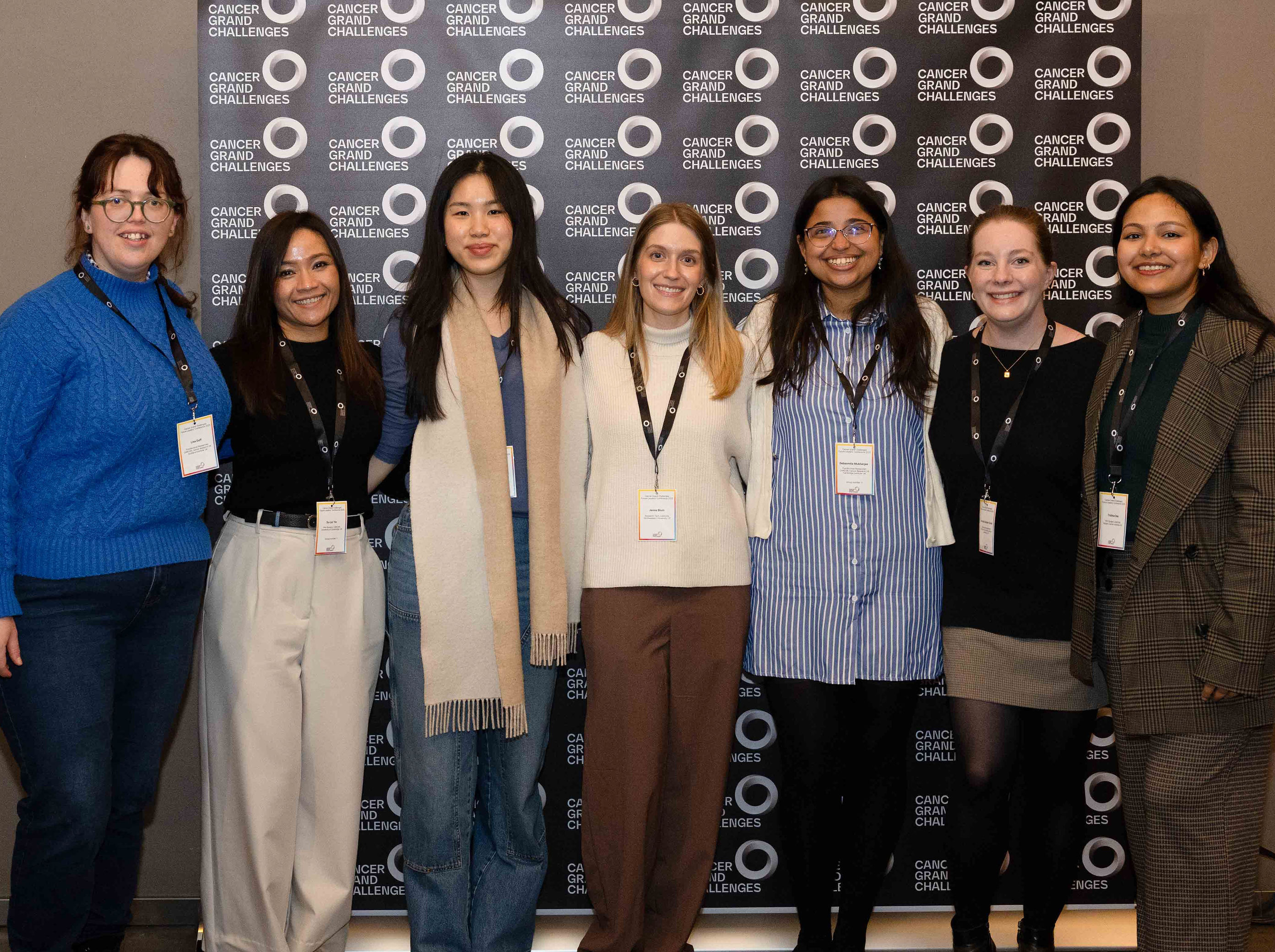 7 Research Scientists Standing in front of black photo backdrop