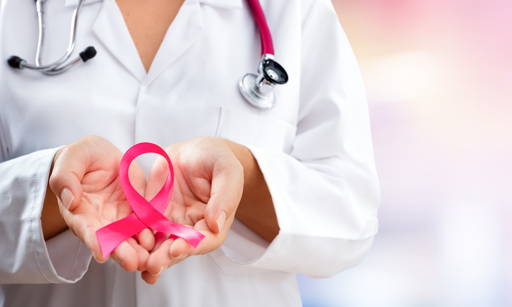 Doctor holding a pink looped breast cancer ribbon