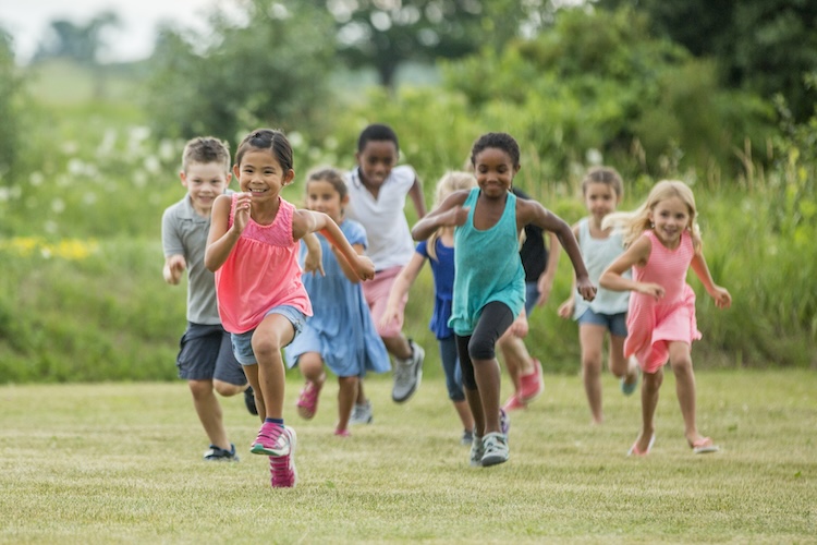 Numerous children running across a field